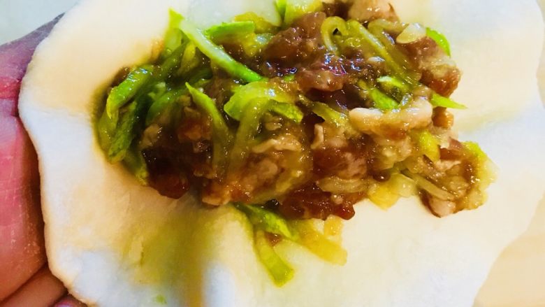 香煎锅贴儿,和好肉馅 就这样把肉馅放在面皮上 两边对折捏在一起 形成一个长条状