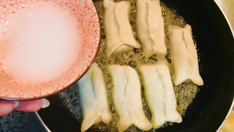 香煎锅贴儿,把捏好的锅贴儿一个一个码放在锅里 这时候用事先调的水淀粉倒入锅中(水淀粉的比例1:5)水淀粉一定要稀薄一些 加入适量水淀粉的目的是为了出锅的锅贴底部有一层薄薄的的咯吱儿 咬着会有脆脆的口感 盖上锅盖小火焖5-8分钟即可食用
