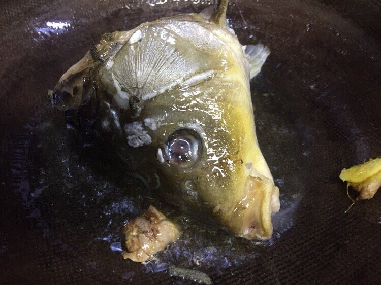 #菌类料理#白玉菇什锦鱼头汤,油温六成放入鱼头老姜煸炒,炒至鱼头变色
