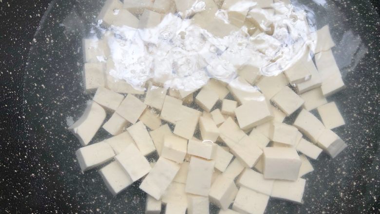 老蛏豆腐,锅里放入一碗水烧开,倒入豆腐焯一下,去去豆腥味,水开煮一分钟捞起来控干水待用