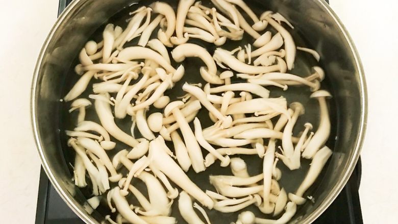 菌类料理+白玉菇烧香卤鹌鹑蛋,锅里加入冷水烧开后加入白玉菇,焯水1分钟
