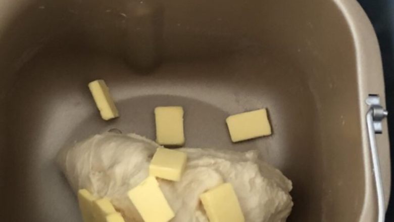 酒渍蔓越莓奶香吐司,放入软化的黄油丁,继续搅打