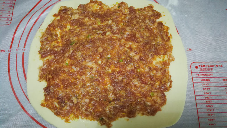 肉龙、懒龙、肉卷,饼上铺上肉馅抹平。末端不要铺的太靠边,以免不好收口。