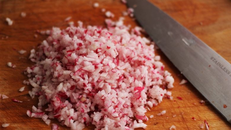 牛肉萝卜饼,把水萝卜冲洗干净后、用工具擦丝后、用刀剁成碎末后,撒上少许盐、这样能使萝卜变软好操作