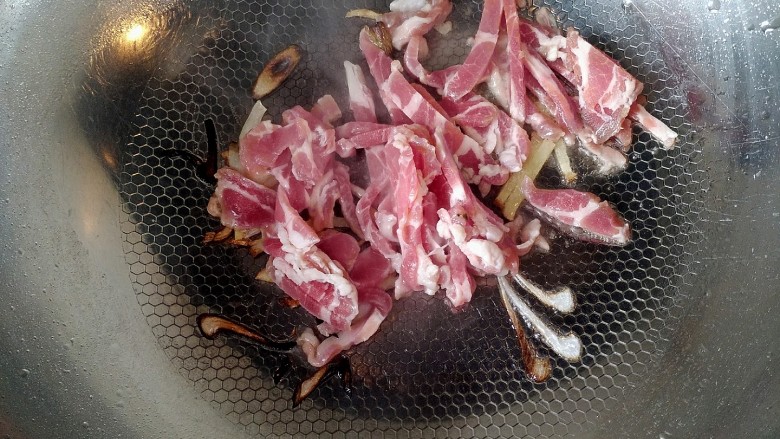 家常芹菜粉条炒肉,下入羊肉翻炒至断生变色。