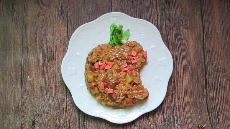 五花肉土豆焖饭,饭煮好后开盖把土豆和饭轻轻搅匀,撒入火腿肠丁,焖10分钟,准备盛出时放一些香油拌匀即可。