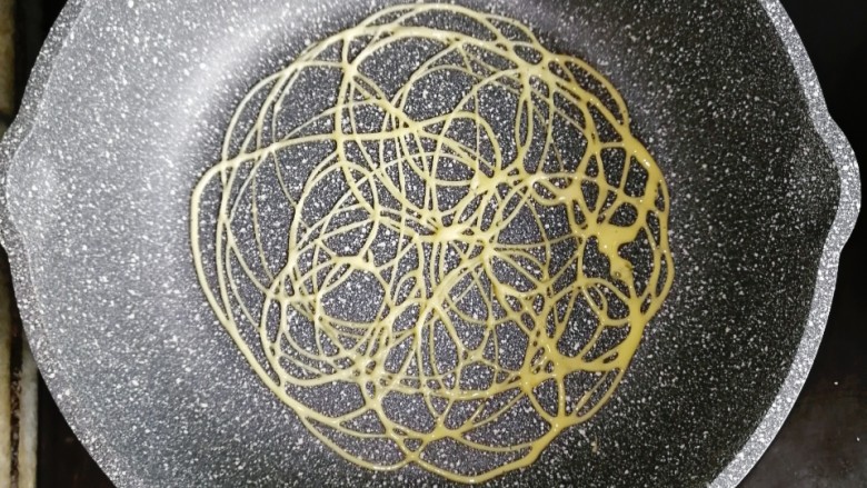 宝宝辅食—网红鸡蛋网格,小火热锅,用画圈圈的方式挤入面糊(全程小火,锅内不需要刷油)