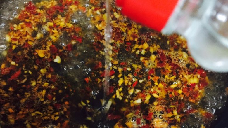自制酸辣粉,加入一碗水到爆香的调料中,同时加入醋