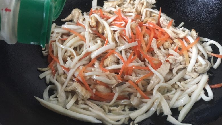 #菌类料理# 蚝油鸡丝杏鲍菇,将锅洗干净,烧热,放入20ml的油,当油温4或者5成热时放入姜丝、葱花煸炒出香味,放入鸡丝、杏鲍菇丝、胡萝卜丝,撒入少许的白胡椒粉,迅速煸炒。