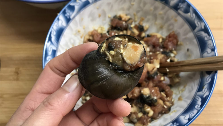 剁椒田螺酿肉,再把拌好的肉塞入洗净的田螺壳中,盖上厣。