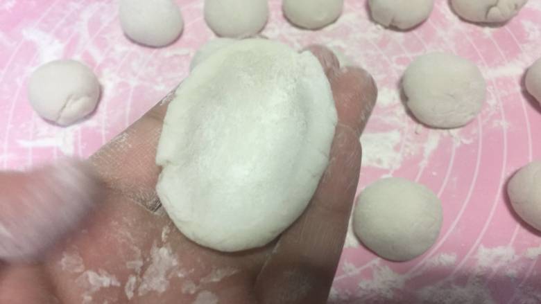 黑芝麻花生汤圆,揪下来一小块 用手团成一个球形 然后按扁 用手按压中间的位置
