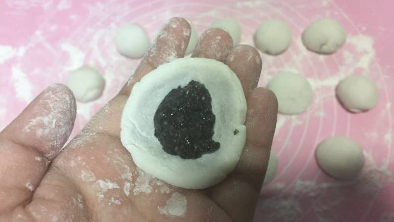 黑芝麻花生汤圆,用筷子夹起一点黑芝麻放在其中
