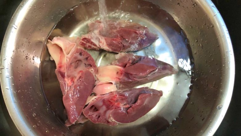 双椒炒猪心,猪心切成四瓣,把血块洗干净,用冷水浸泡1个小时
