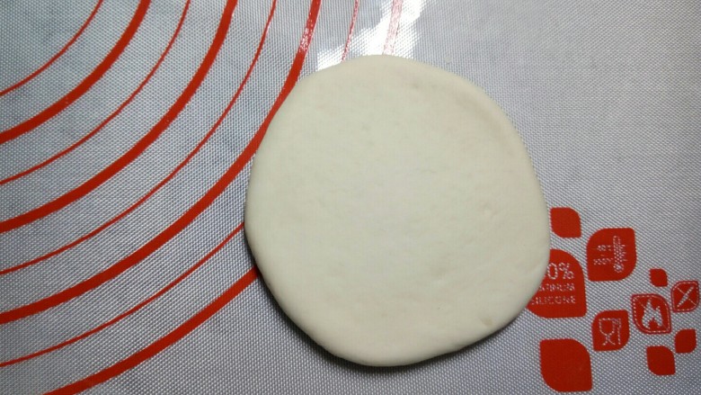 红豆包,取一个小剂子,揉圆摁扁,用擀面杖将皮擀开来。