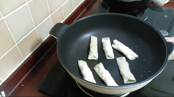 芙蓉鳕鱼锅贴,锅中倒入适量油,小火放入锅贴,慢煎。