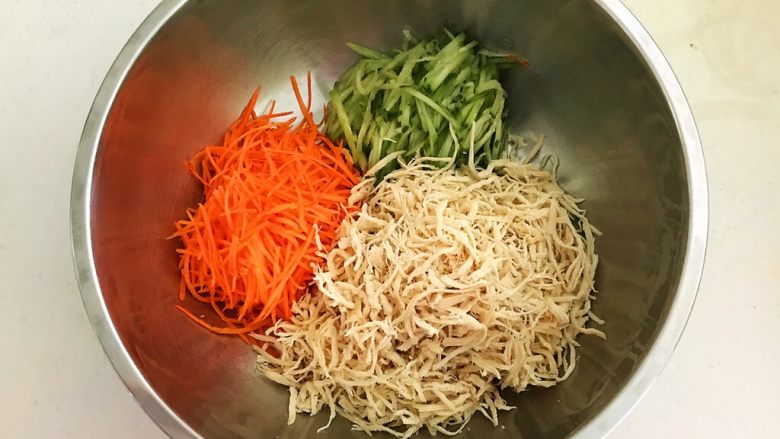 香辣鸡丝,把鸡肉丝,瓜丝和胡萝卜丝放入盆中