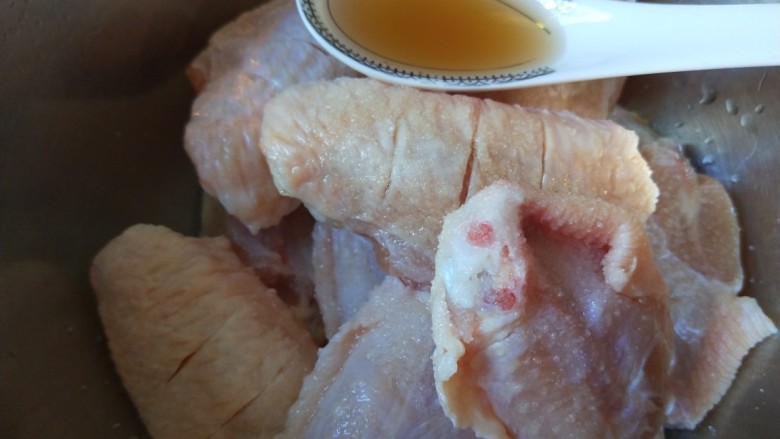 红烧鸡翅,鸡翅放入盆中加适量<a style='color:red;display:inline-block;' href='/shicai/ 718'>料酒</a>，一勺盐。
