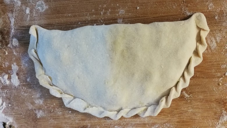 发面菜饼,发面的步骤省略了  将面分成等大小的剂子。擀成圆形 在一半的位置放上做好的馅料。对折成半月形。