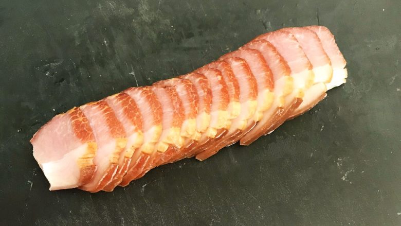 苦菊卷黑椒腊肉,把腊肉捞出来,用厨房纸吸去水分,切成5㎜厚的大片