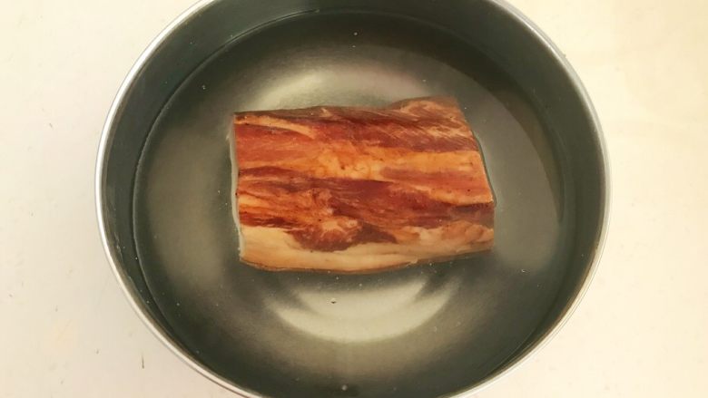 苦菊卷黑椒腊肉,把腊肉清洗干净,放入温水中浸泡2小时,
