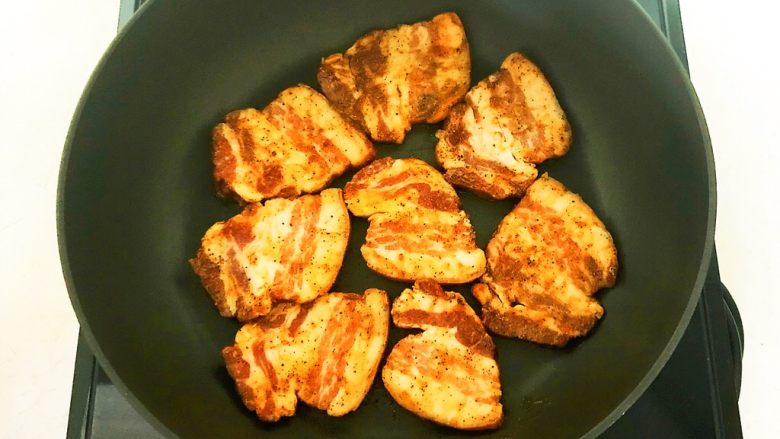 苦菊卷黑椒腊肉,炒锅烧热后放入腌制好的腊肉,小火煎制