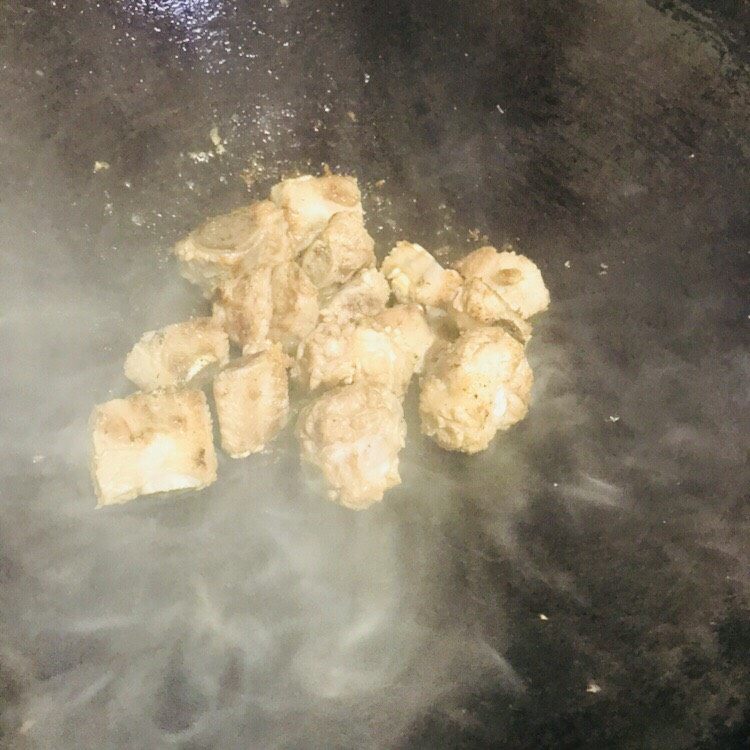 简易家常糖醋排骨,油起锅，下排骨煎至微黄