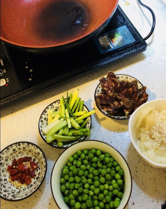 家乡腊肠豌豆饭🍚🥢,云南大理弥渡的香肠有个讲究，就是不放麻辣，却喜欢撒入食盐、草果粉，和50度以上的米酿烈酒。最独特的是，额外还要添加一味红曲米。不仅颜色更粉嫩艳绝，还散发着一股甘甜清香，口感也会愈发嚼劲中略带糯柔…晾晒的时候，光是从旁边走过，闻着味就能联想到一桌美味佳肴。