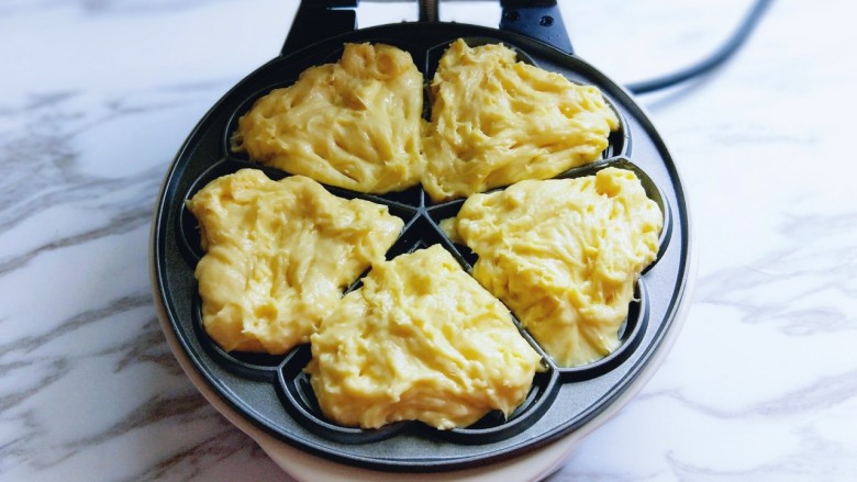 #辅食计划#华夫饼~酵母版,这时面糊也发酵好了,用勺子盛一勺倒在烤盘模具中。