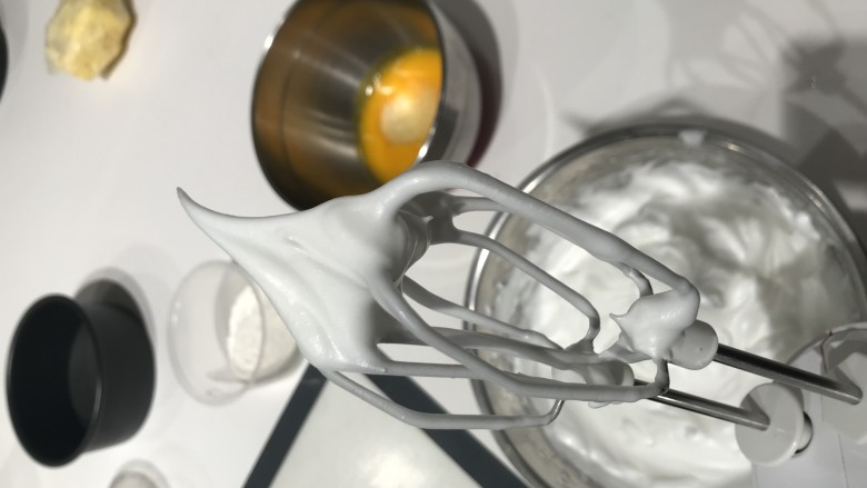 巧克力奶盖蛋糕,在蛋白液中滴三滴柠檬汁或柠檬醋,用电动打蛋器先低速后高速打发蛋白,蛋白打发至粗泡、泡沫细腻、出现纹路,分三次加入细砂糖,打发至蛋白硬性发泡,提起来泡沫出现正三角形。
