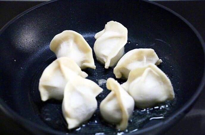 煎饺抱蛋,平底锅放入少许油,把饺子排开摆好(如图)小火煎两分钟左右,底部就会煎出漂亮的金黄色