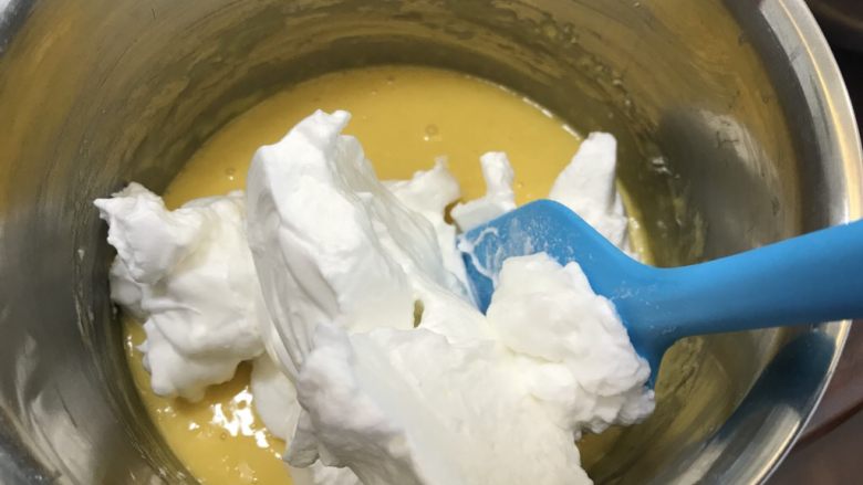 爆浆海盐奶盖蛋糕,取三分之一蛋白霜加入到蛋黄糊中,切拌法拌均匀