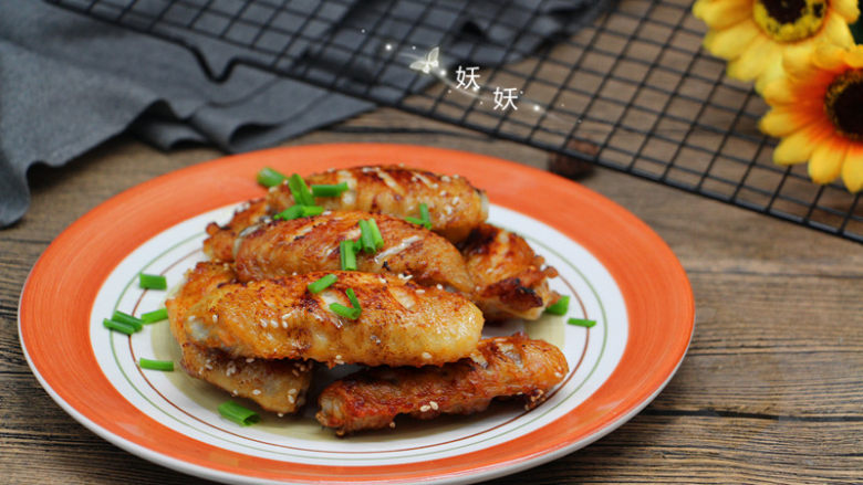 奥尔良煎鸡翅,待芝麻也煎出香味就可出锅,撒些<a style='color:red;display:inline-block;' href='/shicai/ 157'>小葱</a>碎装饰提味即可。