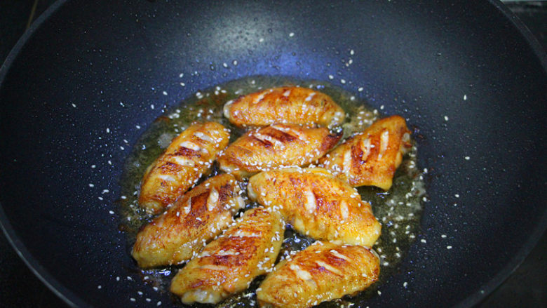 奥尔良煎鸡翅,鸡翅煎的金黄不冒血水,撒入<a style='color:red;display:inline-block;' href='/shicai/ 666'>芝麻</a>,撒在鸡翅上,再煎一两分钟。