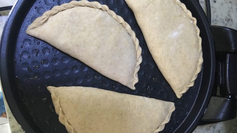 韭菜盒子,放入韭菜盒子🥙,盖上电饼铛的盖子,上下火煎一两分钟后翻面