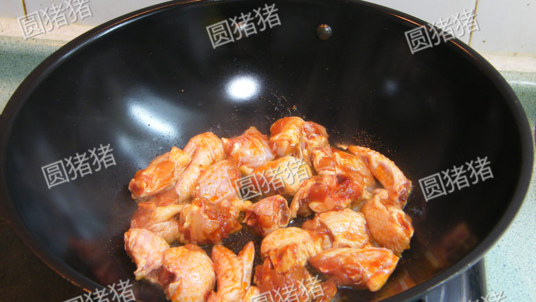 红亮诱人——麻辣鸡翅,锅内烧热油,中小火,放入腌好的鸡块炒制。
