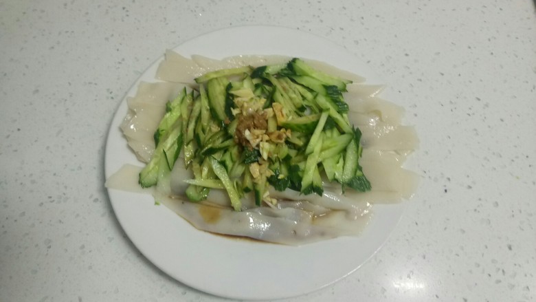 自制凉皮,加入黄瓜丝、蒜末,倒入调好的料汁。