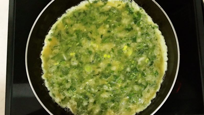香椿系列之二 香椿鸡蛋饼,油烧热后加入香椿鸡蛋液,小火煎制,鸡蛋液定型,底面金黄色就可以翻面了