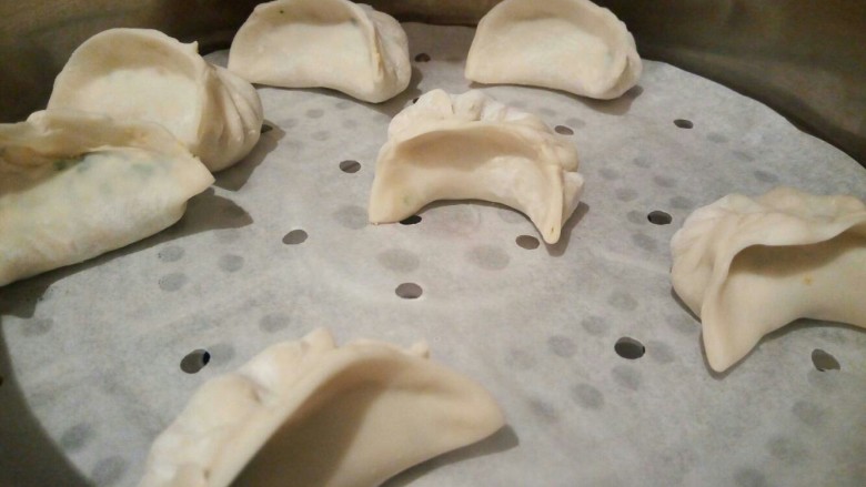 营养早餐【沙葱蒸饺】,蒸锅添上水,水开,垫一张油纸,放上饺子,盖好盖子,上汽以后,大火再蒸5分钟。
