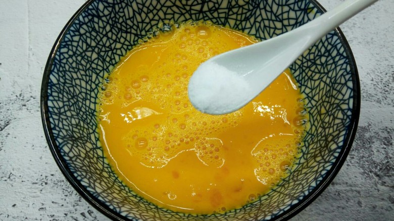 营养早餐【沙葱蒸饺】,用筷子顺时针把鸡蛋液打散,加半勺盐