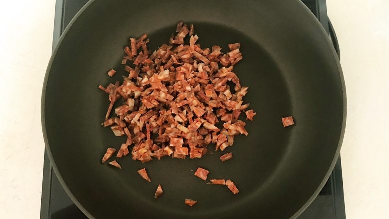 香椿系列之四 法式香椿煎饼,炒锅烧热后加入1小勺大豆色拉油,油烧热后加入腊肠丁
