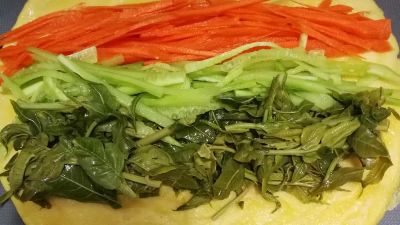香椿蔬菜蛋皮卷,冷却的的蛋皮上码上香椿段,黄瓜丝,胡萝卜丝。