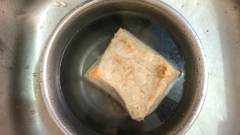 梅菜扣肉,五花肉炸好拿出来,放冷水里浸泡一个小时,泡至肉皮变软即可