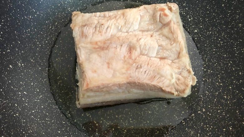 梅菜扣肉,锅里放入适量油,五花肉放入锅中,肉皮朝下,盖上锅盖,小火炸至肉皮焦黄