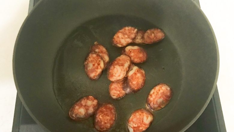 黑椒腊肠炒意面,锅里加入腊肠,翻炒1分钟