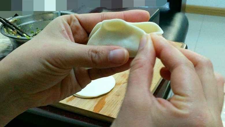 三鲜饺子的多种吃法,现在中间捏一下,再从边上往里捏。