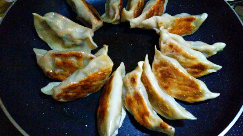 三鲜饺子的多种吃法,第三种吃法,三鲜锅贴,做法:锅里放油饺子下锅,小火慢煎,底部微黄后加入一小半碗水,盖上锅盖闷煮2分钟,打开锅盖开吃。(有点类似生煎的做法)