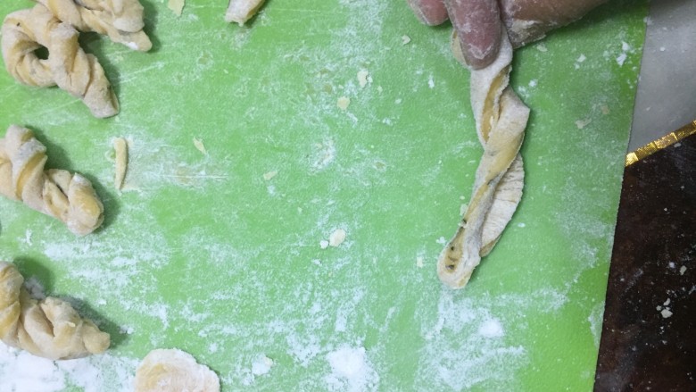 酥脆小麻花(教你做出又酥又脆0失败的麻花),两边朝反方向扭转,两只手朝不同方向扭转,直到成两条交叉的条状。