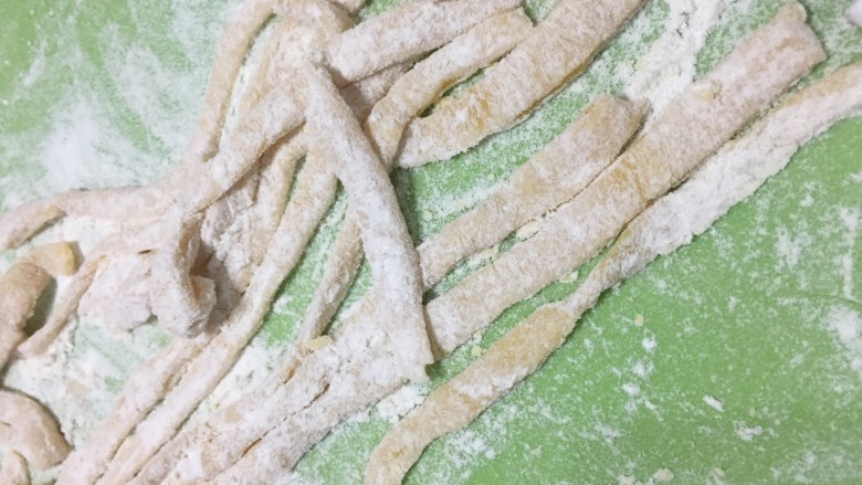 酥脆小麻花(教你做出又酥又脆0失败的麻花),然后把面条都展开,盖上保鲜膜防止面条干掉。撒上少许干粉 不要撒太多,否则后面会散开,形状也不好看了。
