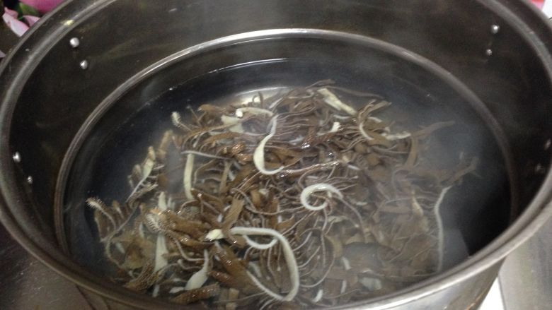 芫爆毛肚,笊篱内放入毛肚丝焯烫5、6秒,肚丝微微打卷,有微弱弹性了即可,捞出控水