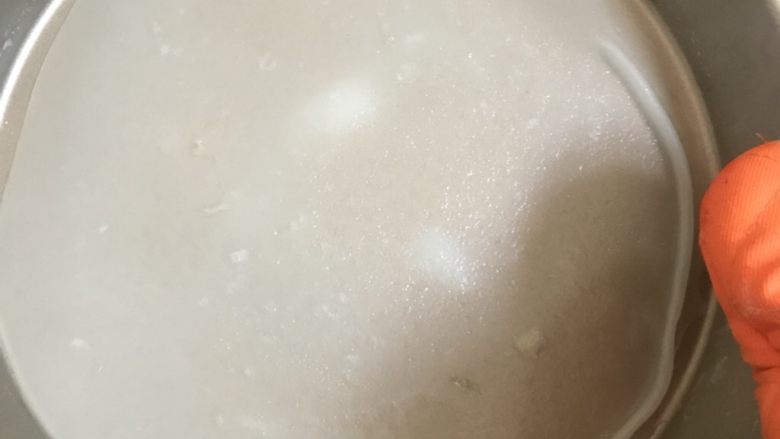 自制凉皮,蒸好的面皮稍微凉一点就可以取下来了。然后再舀入一勺面糊,继续蒸。